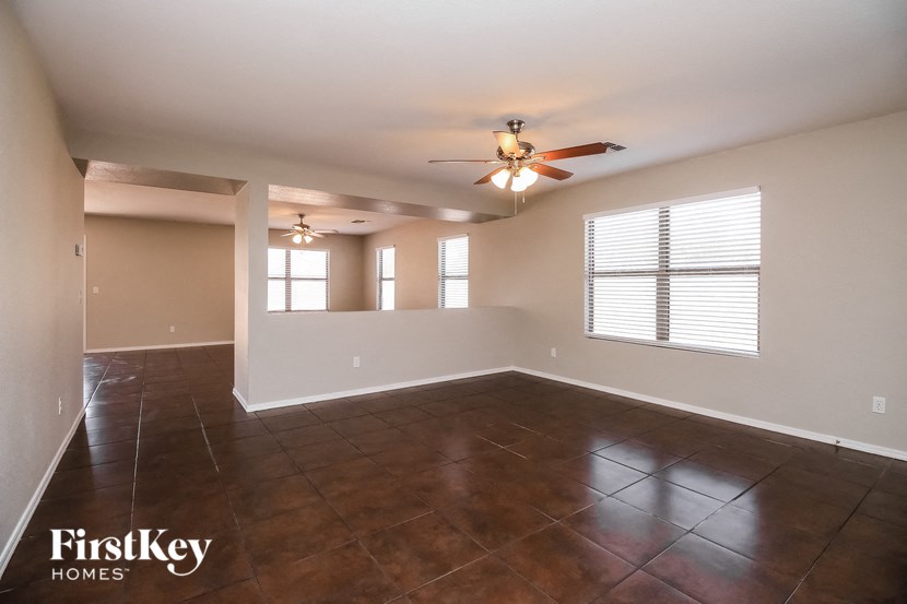 a empty living room with a ceiling fan and a window