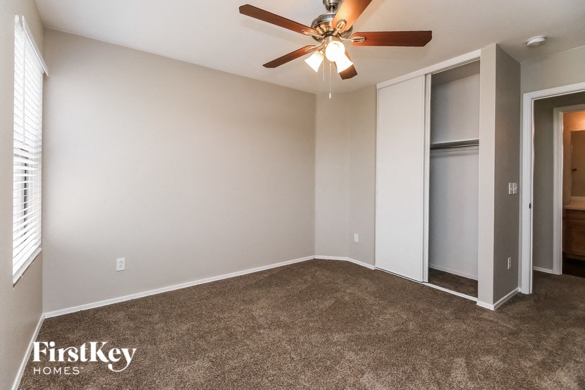 an empty room with a ceiling fan and a closet