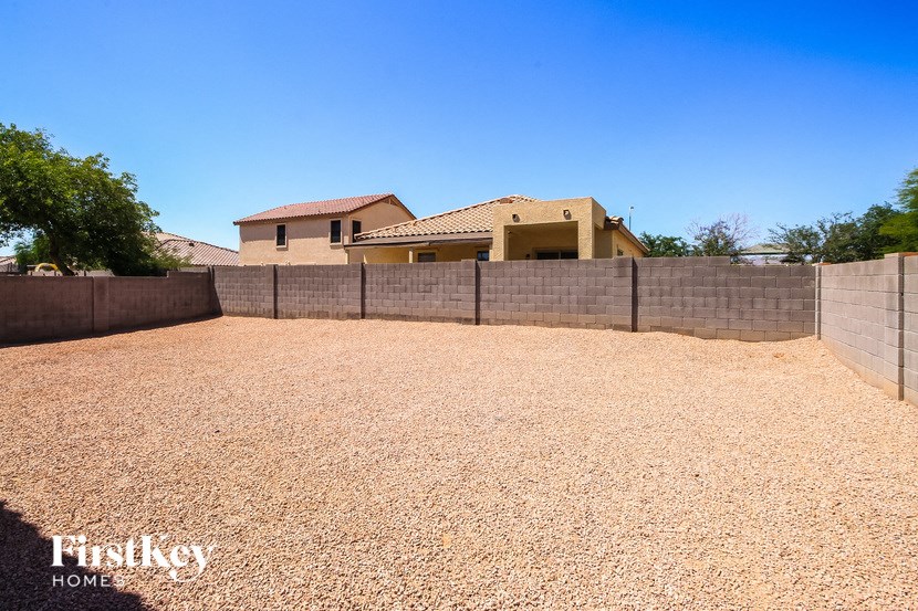 a backyard with a fence and a house in the background