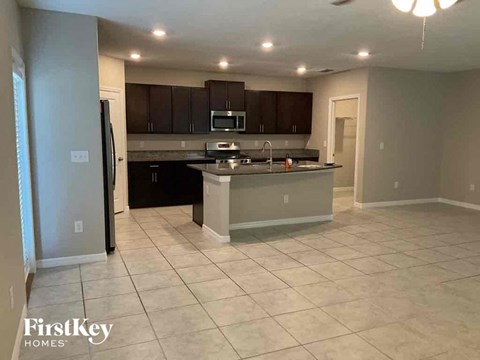 A kitchen with a black counter top and a white fridge.