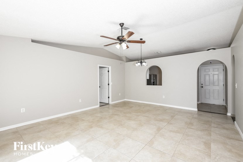 an empty living room with a ceiling fan