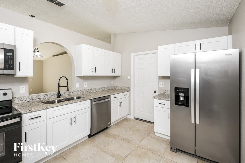 a kitchen with white cabinets and stainless steel appliances