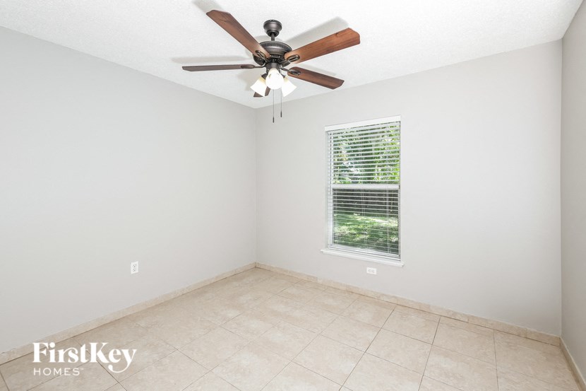 a room with a ceiling fan and a tiled floor