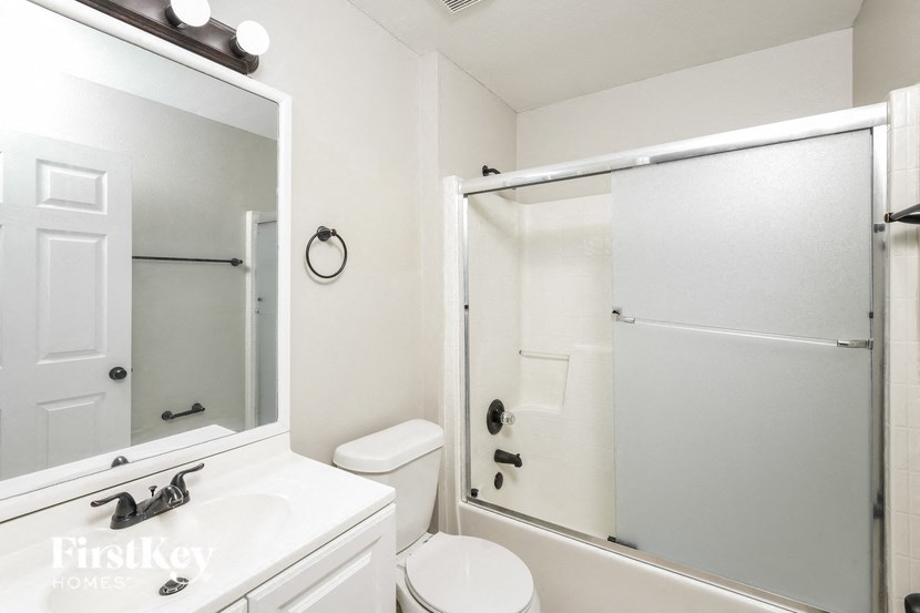 a white bathroom with a shower and a sink and a toilet