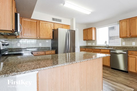 a kitchen with wooden cabinets and granite counter tops