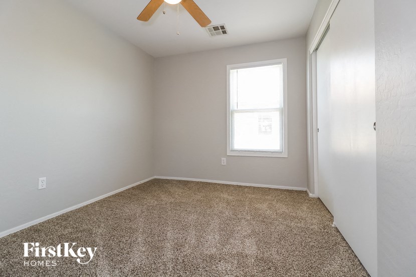 an empty room with a window and a ceiling fan