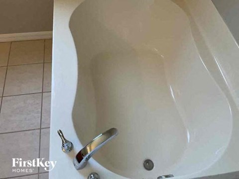 a white bath tub with a silver faucet in a bathroom