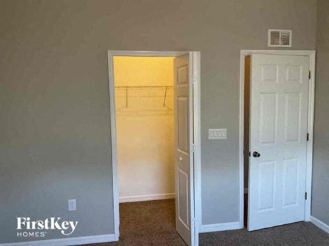 an empty room with an open door and a closet