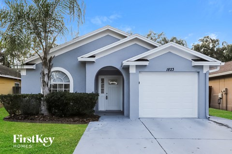 a blue house with a white driveway and a white garage door