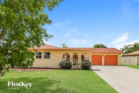 a house with a lawn and a orange garage door
