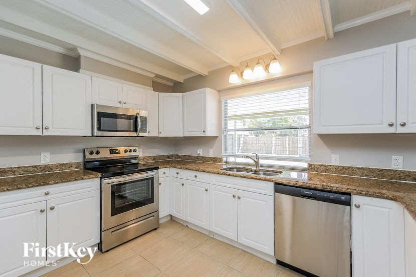 a kitchen with white cabinets and stainless steel appliances