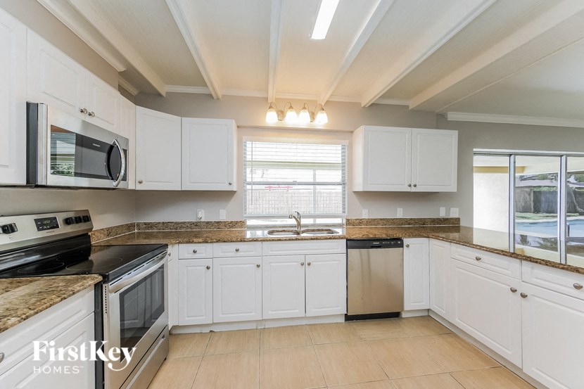 a large kitchen with white cabinets and granite counter tops