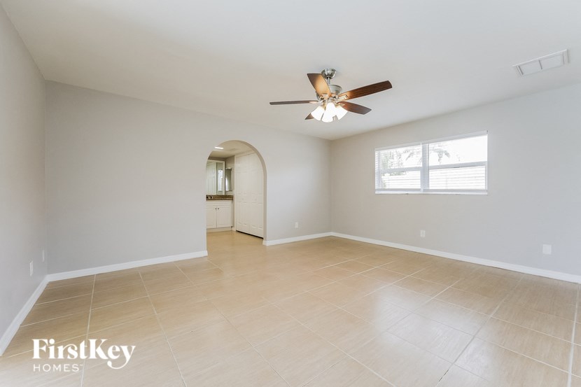 an empty living room with a ceiling fan