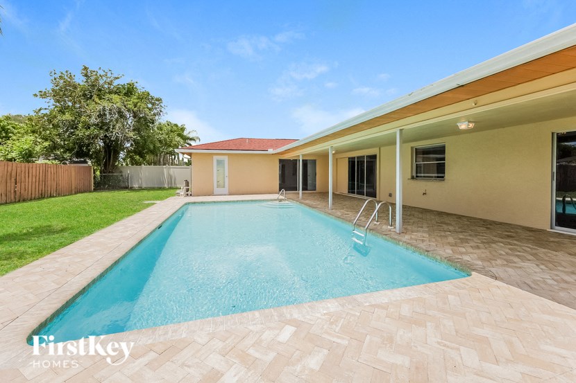 a swimming pool in the backyard of a house with a pool