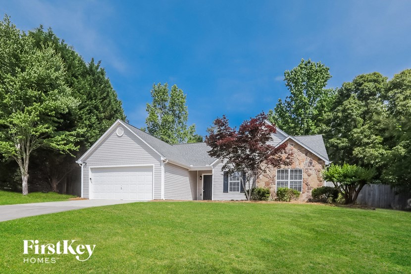 a white and brick house with a yard and a garage