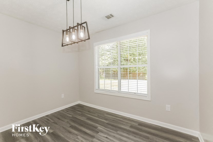 an empty room with a window and a chandelier