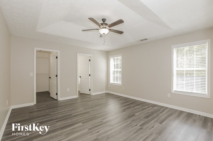 the living room of an empty house with a ceiling fan