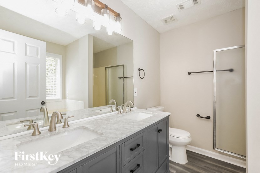 a bathroom with two sinks and a shower and a toilet