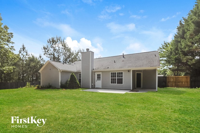 a white house with a grassy yard and a fence