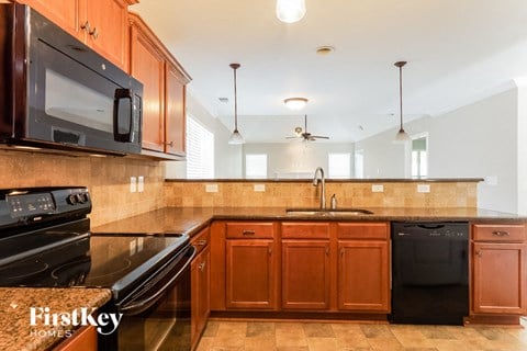 A kitchen with wooden cabinets and black appliances.