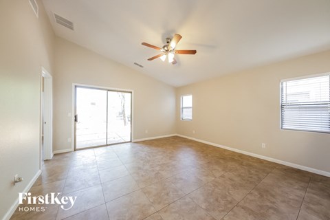 A spacious room with a ceiling fan and sliding glass doors.