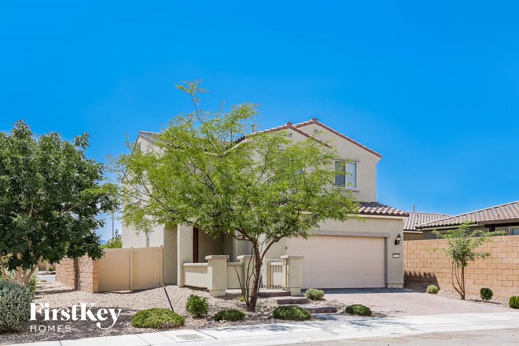 a house with a garage door and a tree in front of it