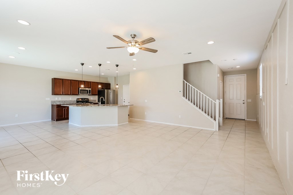 an empty kitchen and living room with a ceiling fan