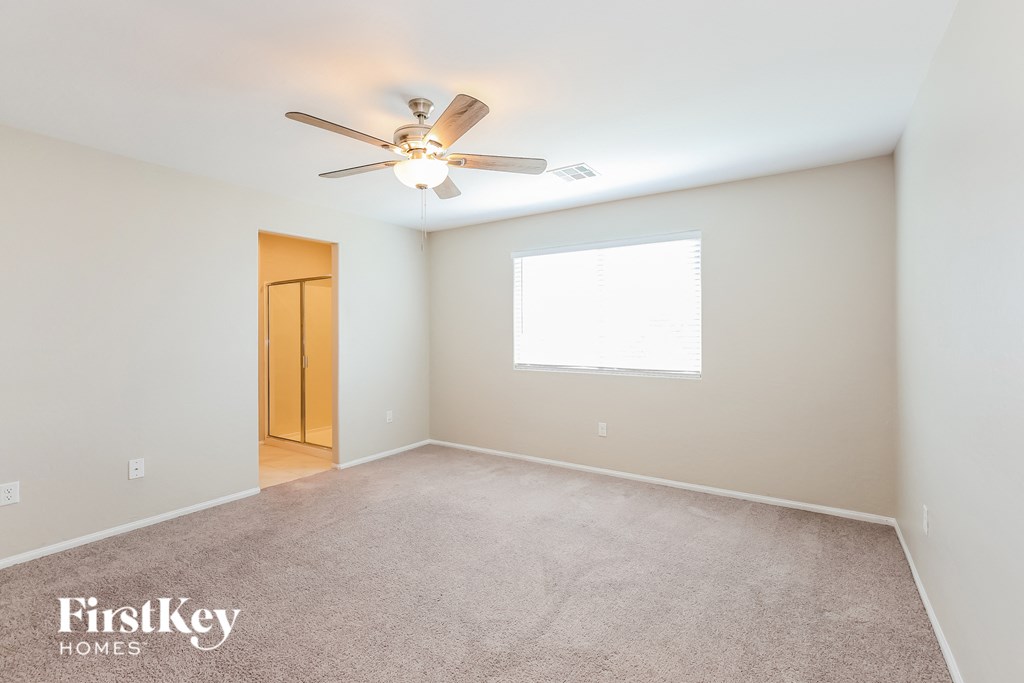 a empty room with a ceiling fan and a window