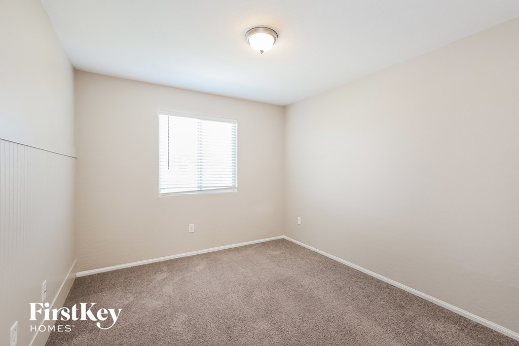 a bedroom with a carpeted floor and a window