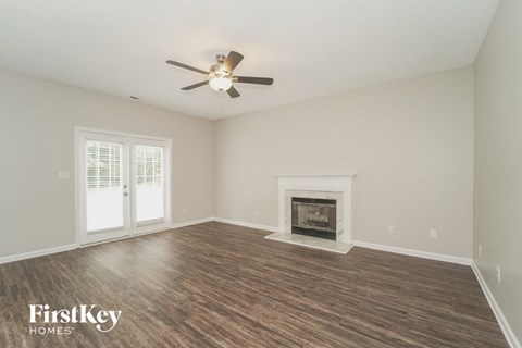 A room with a fireplace and a ceiling fan.