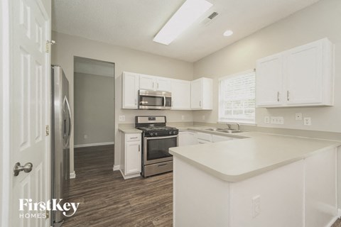 A kitchen with white cabinets and a white island.