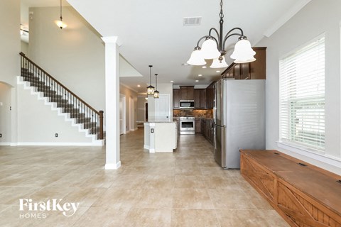 a kitchen with a stainless steel refrigerator and a staircase