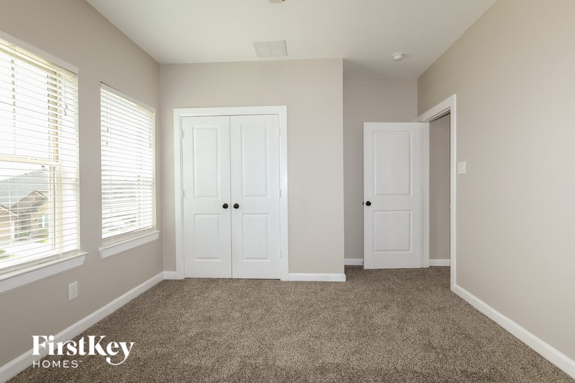 a bedroom with two doors and a carpeted floor