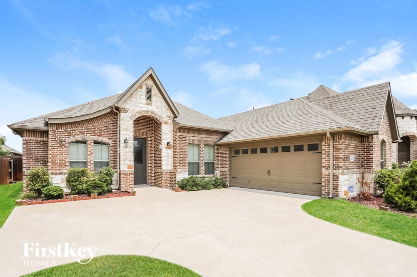 A brick house with a garage door and a driveway.