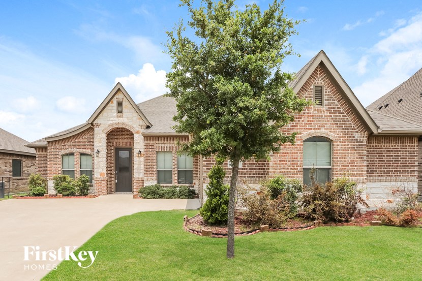 A brick house with a tree in front of it.
