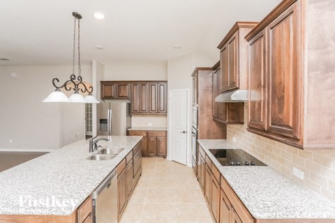 A kitchen with wooden cabinets and a marble countertop.