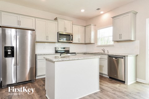 a white kitchen with stainless steel appliances and white cabinets