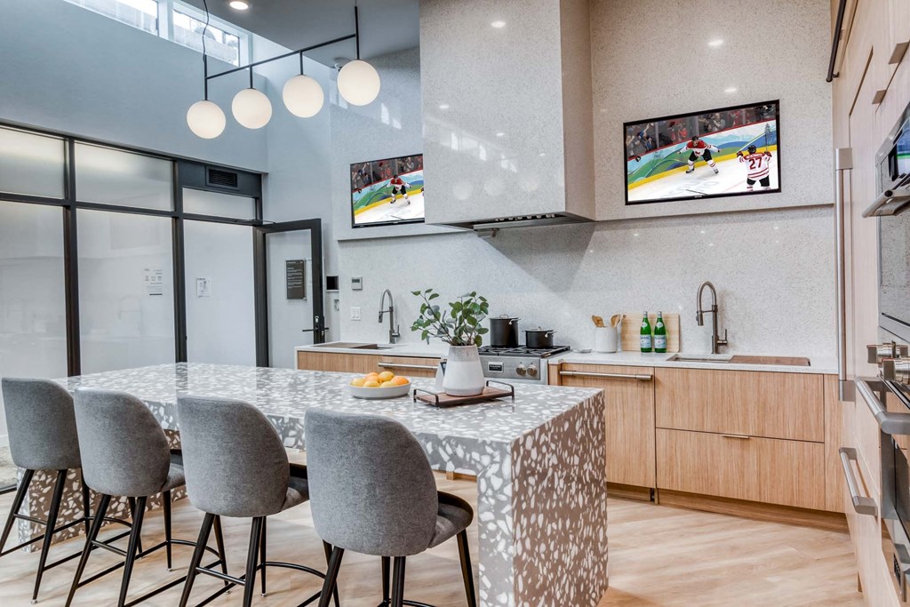 A modern kitchen with a dining table and grey chairs.