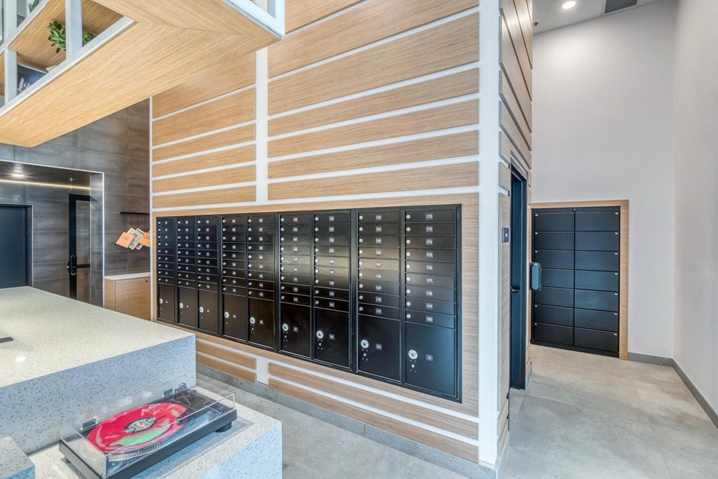A modern locker room with black lockers and a wooden wall.