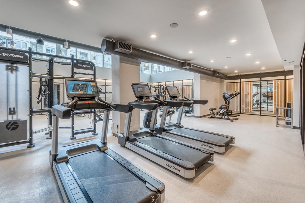 A gym with treadmills and elliptical machines.