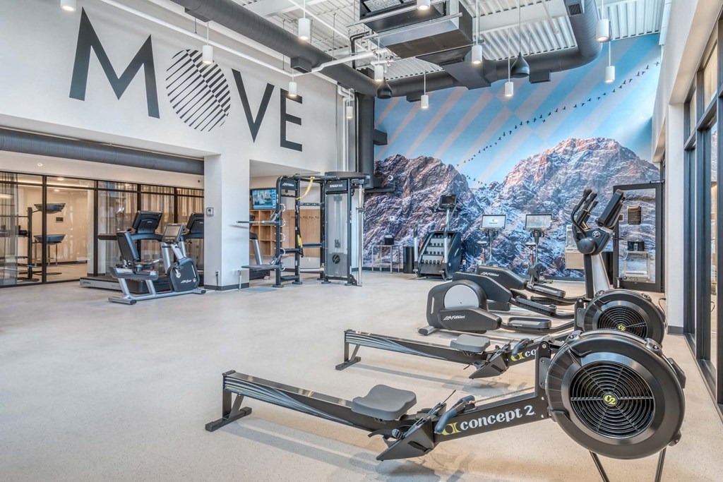 A gym with a large mural of a mountain and the word MOVE on the wall.