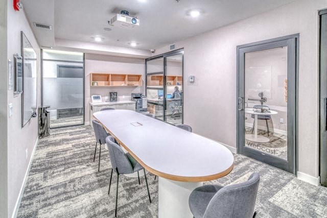 A conference room with a long table and chairs.