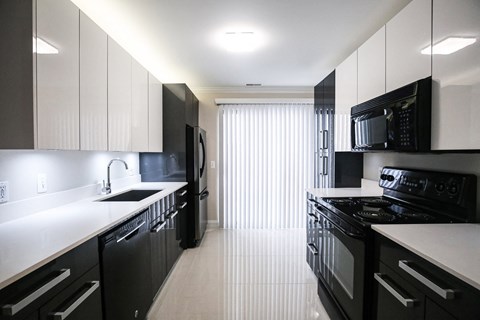 a black and white kitchen with black appliances and white counter tops