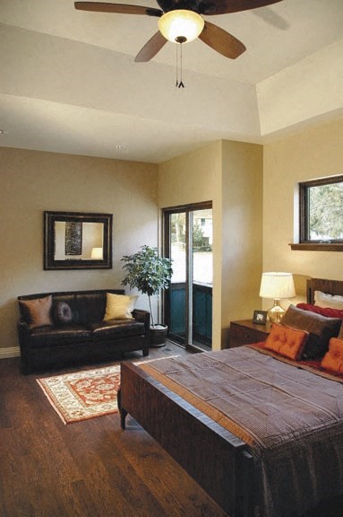 a bedroom with a bed and a couch and a ceiling fan