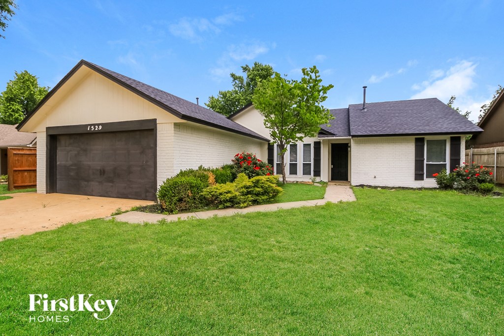 A house with a garage and a driveway is for sale.