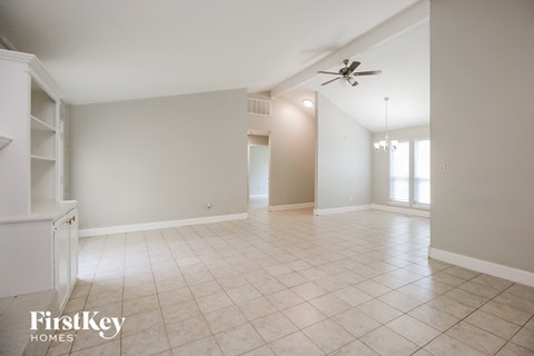 A spacious room with a ceiling fan and tiled flooring.