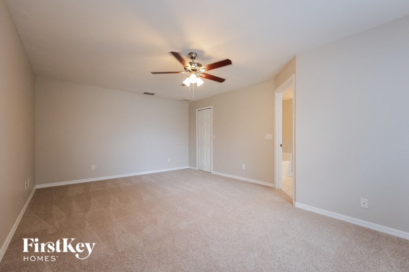 an empty living room with a ceiling fan