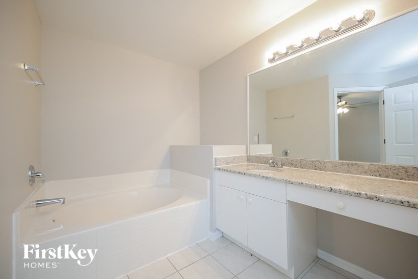 a bathroom with a tub and a sink and a mirror