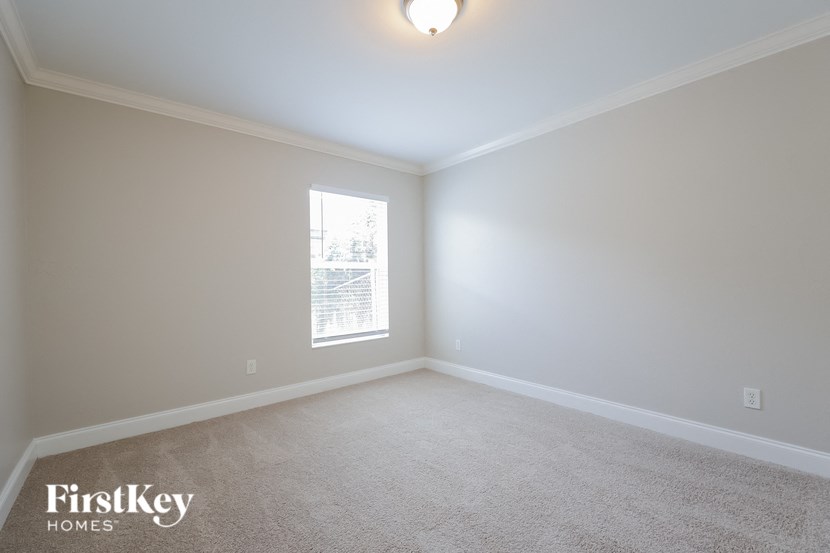 a bedroom with a carpeted floor and a window