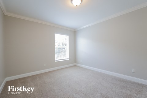 a bedroom with a carpeted floor and a window